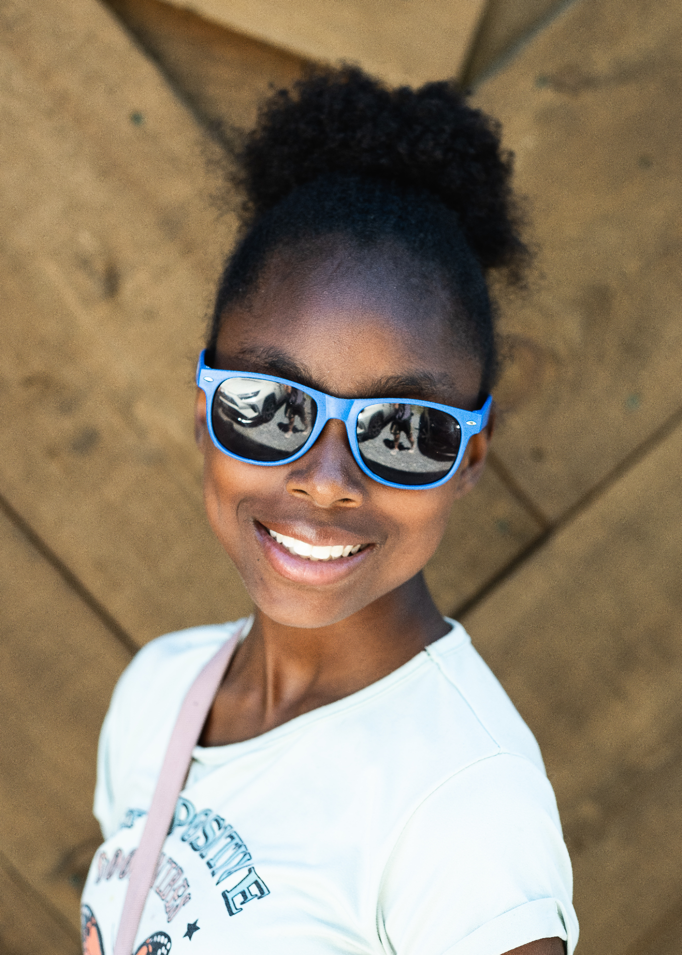 A Sisters Circle mentee smiling in blue sunglasses
